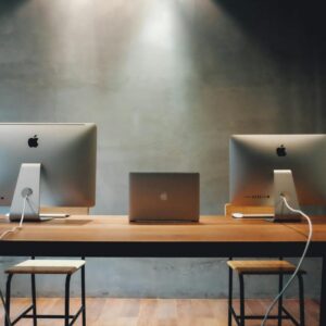 Minimalist office space with dual monitors on a wooden table, promoting a contemporary work environment.